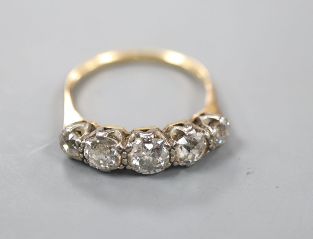 An early 20th century yellow metal and graduated five stone old cut diamond ring, size R, gross 3 grams.